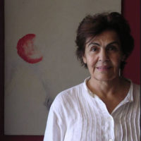 Simone Fattal contributor photo, indoors in front of painting with a red half-circle