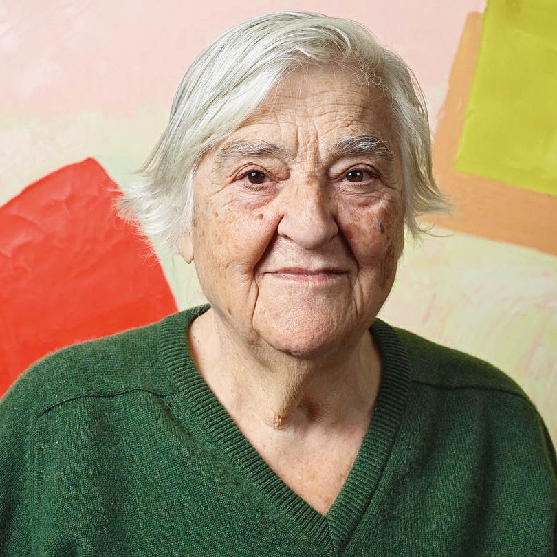 Etel Adnan contributor photo, in front of painting with colorful squares