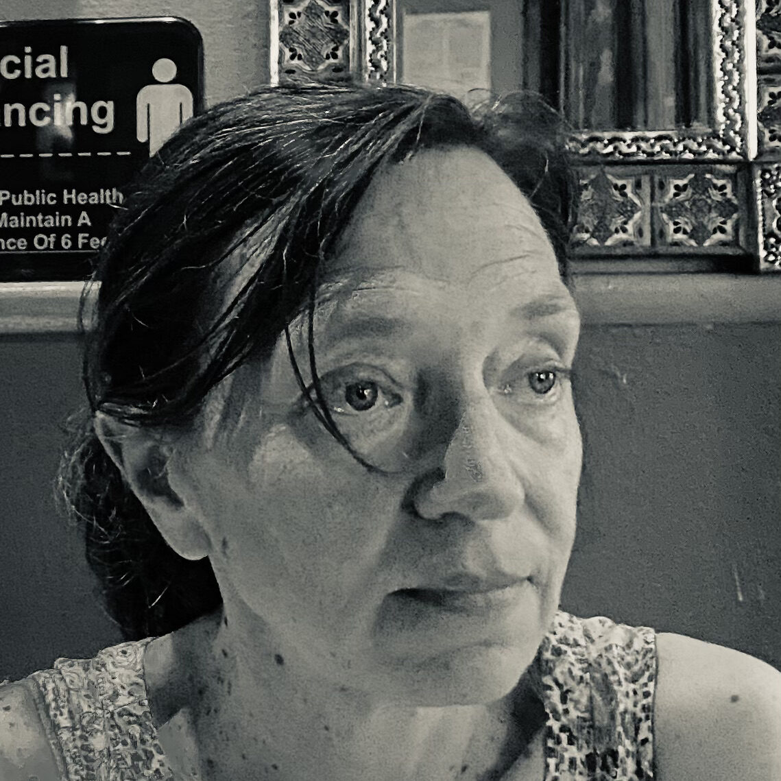 Headshot of Eléna Rivera seated in a restaurant booth in black and white